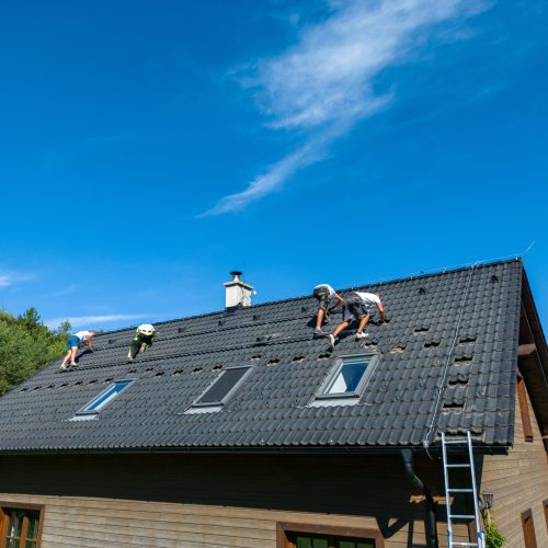 Men worker installing solar photovoltaic panels on a roof, alternative energy, saving resources and sustainable lifestyle concept.