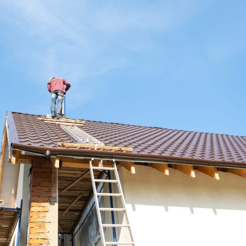 The master for the installation of ventilation pipes and the ins The master for the installation of ventilation pipes and the installation of the chimney of the furnace works on the roof of the house