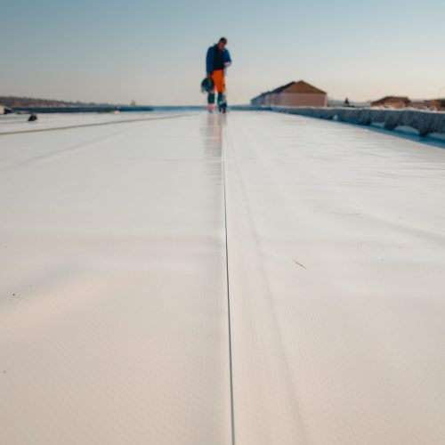 Waterproofing and insulation at construction site, waterproofing Waterproofing and insulation at construction site, waterproofing membrane preventing water penetration. Exterior vapor barrier for roof.